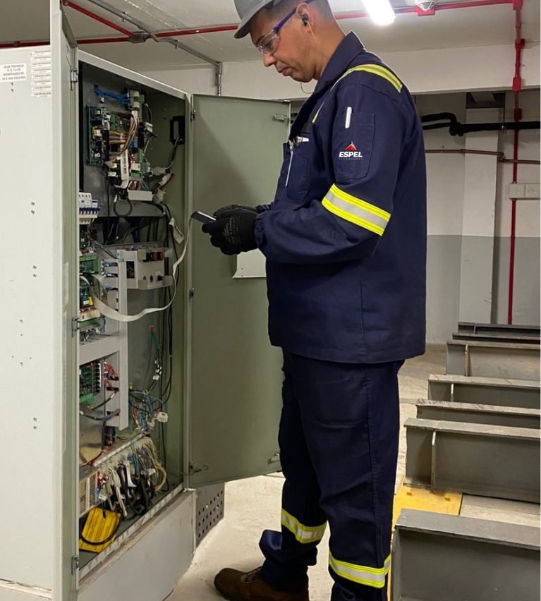 Técnico da Espel analisando o quadro de comando eletrônico de um elevador